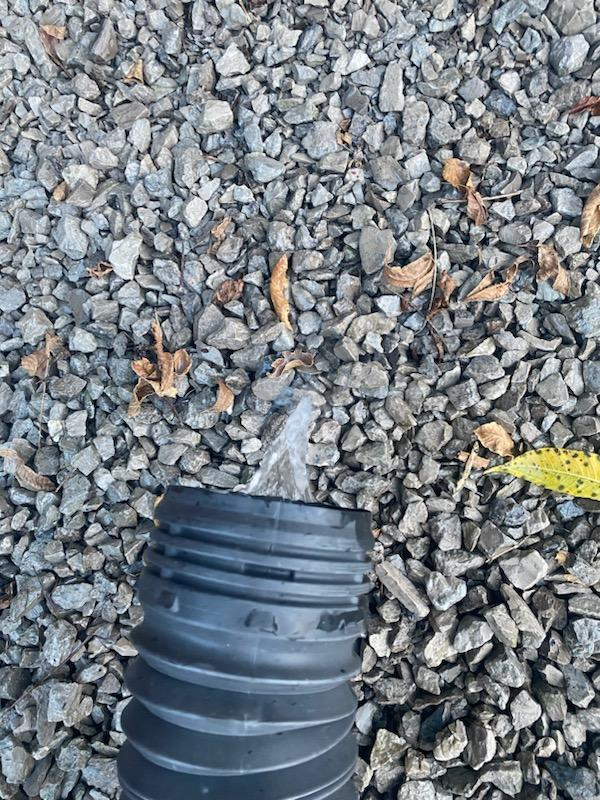Black pipe draining into gravel